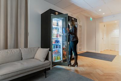 Mujer agarrando una botella de una maquina expendedora