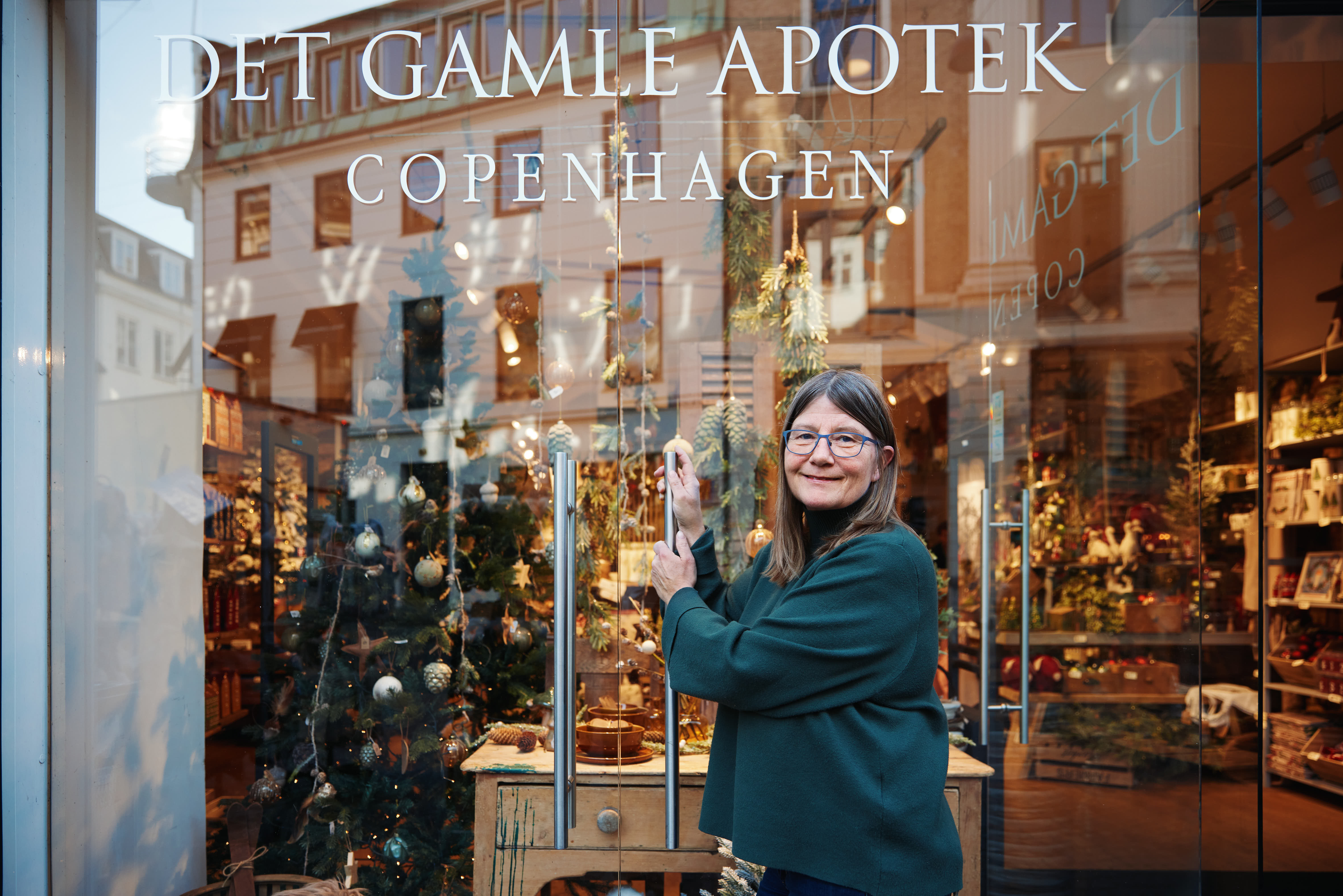 Dueña de tienda de articulos de navidad en el escaparate