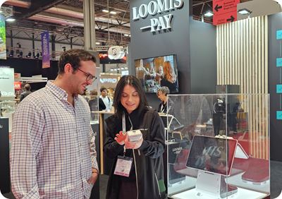 Equipo haciendo una demostración de Loomis Pay en feria HIP a un posible cliente