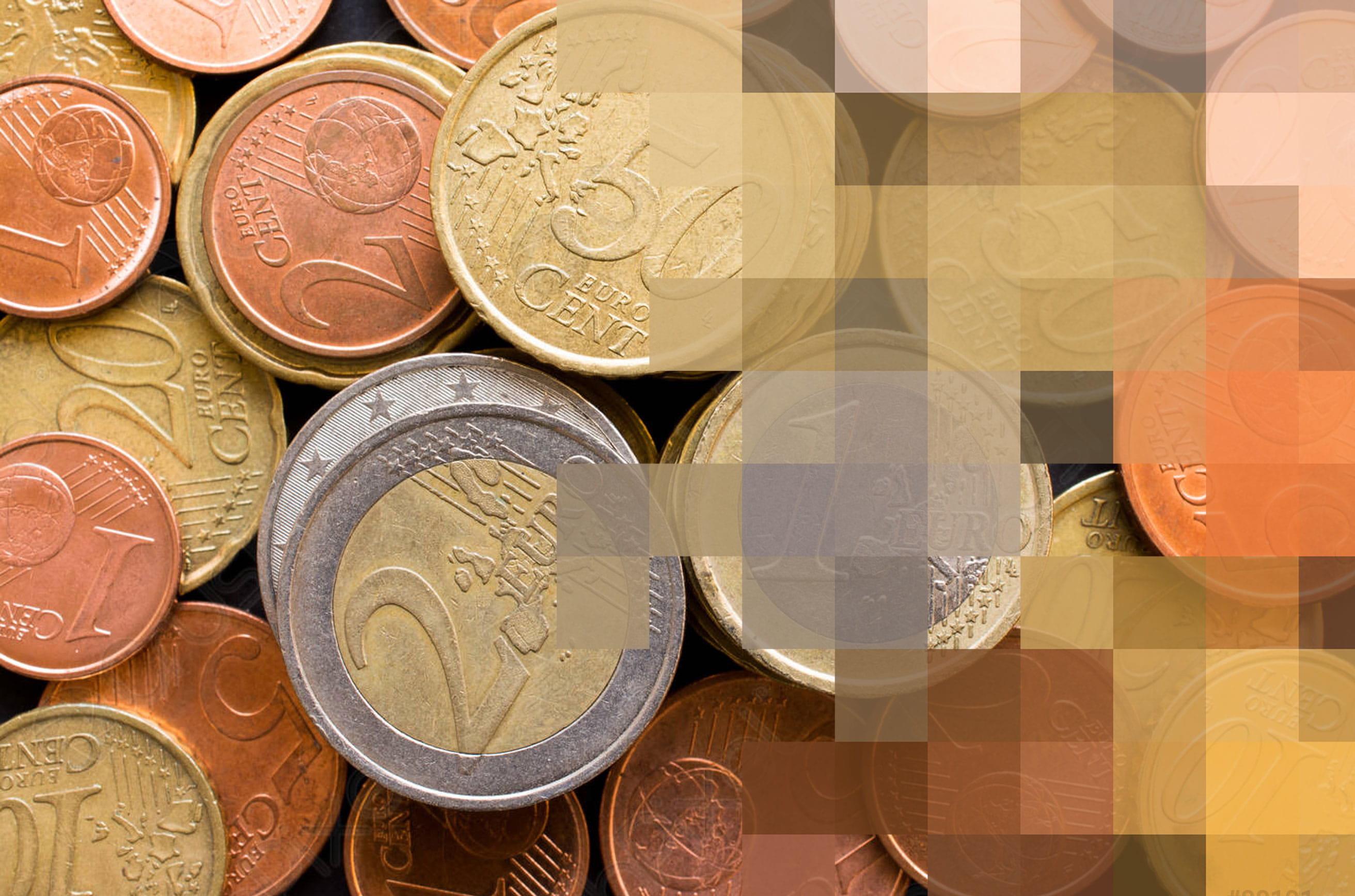 Varias monedas de diferentes denominaciones apiladas y esparcidas, con un ligero difuminado en el lado izquierdo de la imagen.