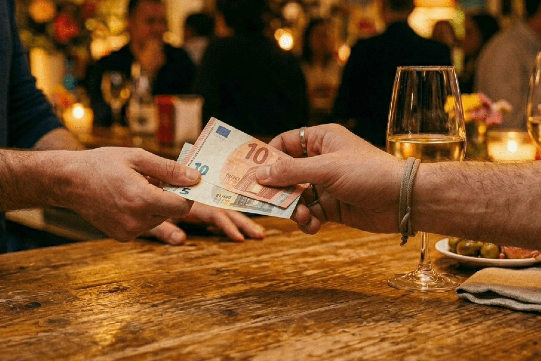 mano de cliente pagando con billetes en la barra de una caseta de la feria de abril 2026