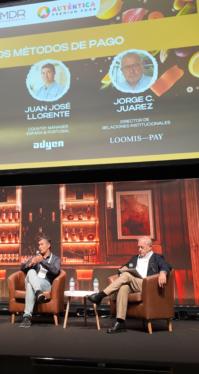 Jorge C. Juárez interviniendo con micrófono en la mesa redonda sobre pagos en hostelería
