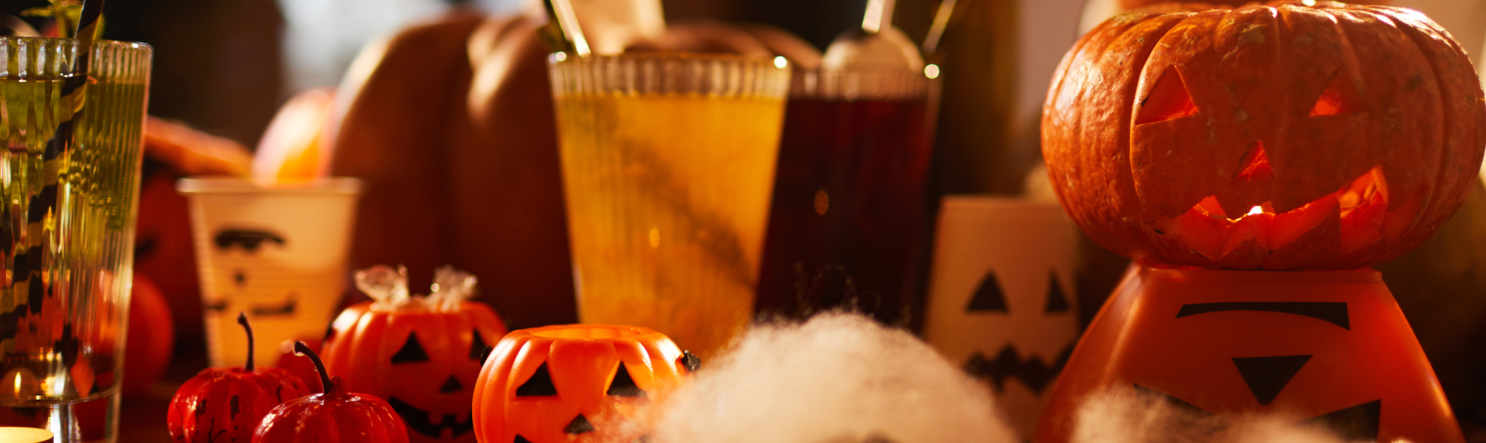 Entrada de un restaurante con decoración sobria de Halloween: calabazas, velas LED y luz cálida