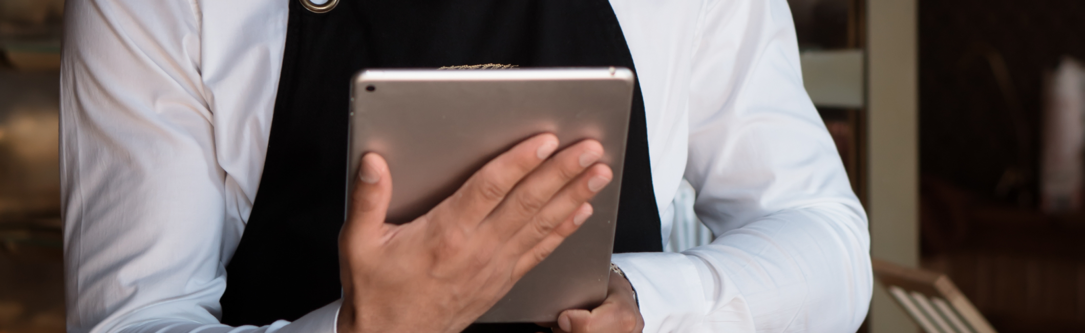 Gerente de restaurante revisando datos de ventas en una tablet junto al TPV