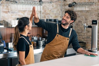 Empleados de cafeteria chocandose la mano felices