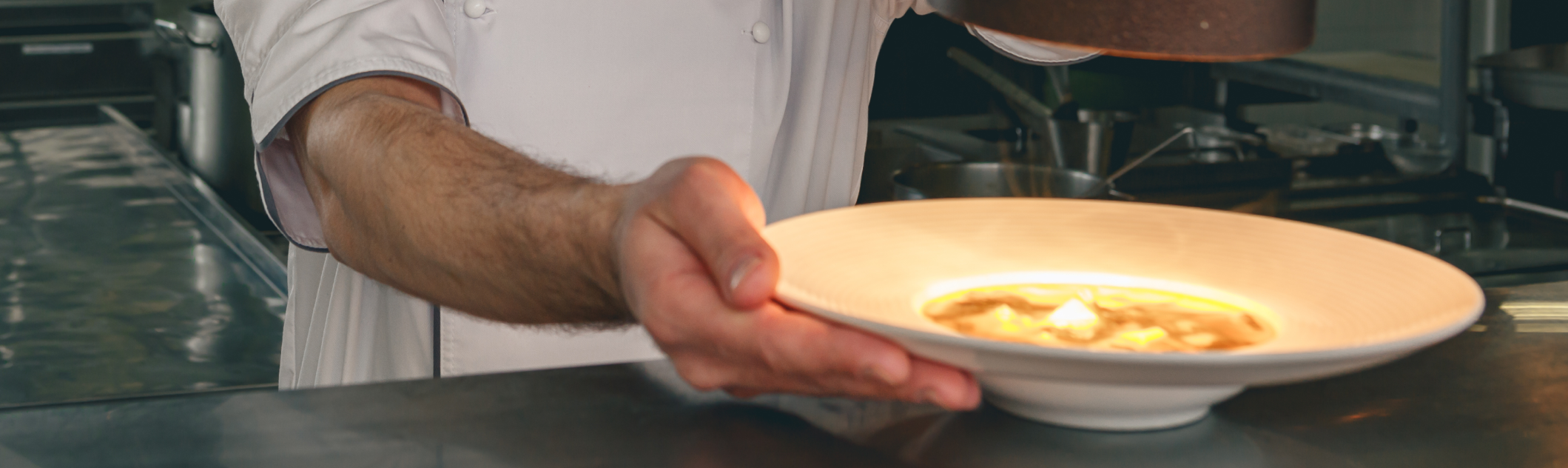Pase de una cocina profesional con comandas y platos listos para salir a sala